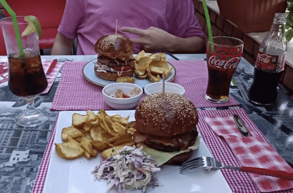 Burgeri cu cartofi prăjiți și Cola la masă